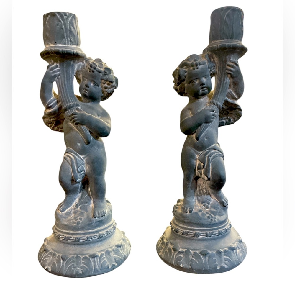 A pair of cherub candle holders by, Omamental Arts, Inc.